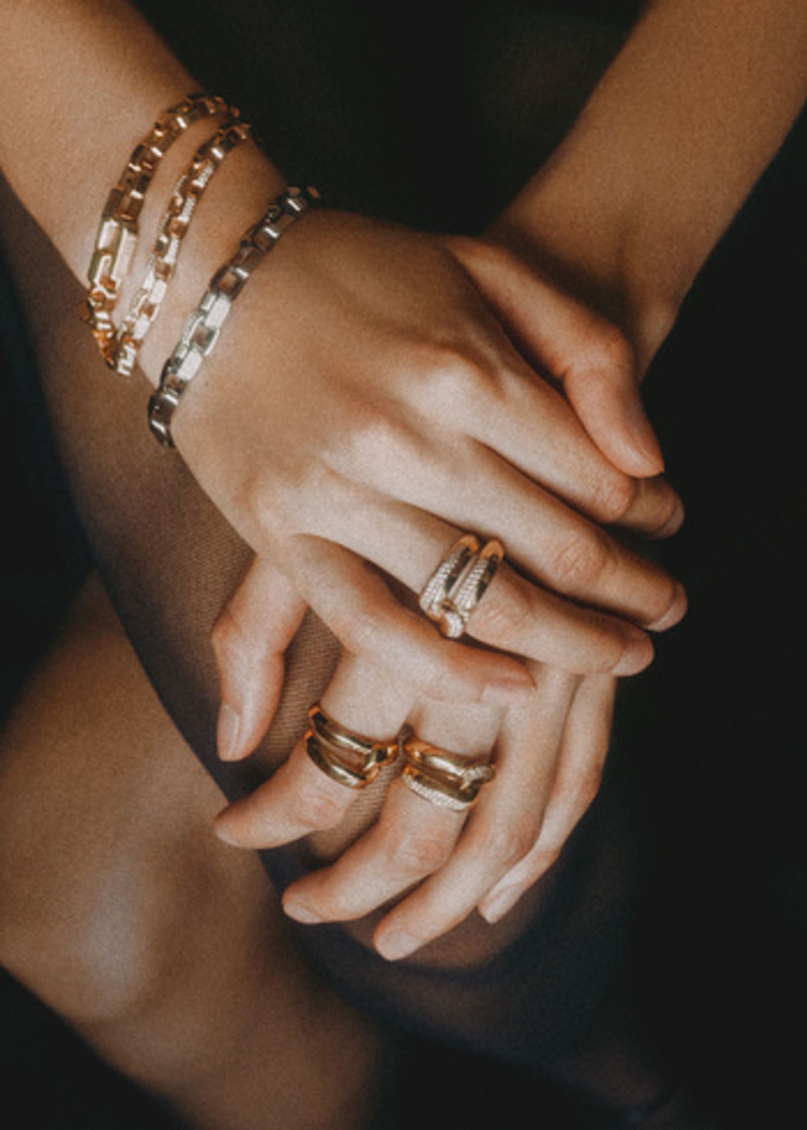 a woman's hands with gold rings on them