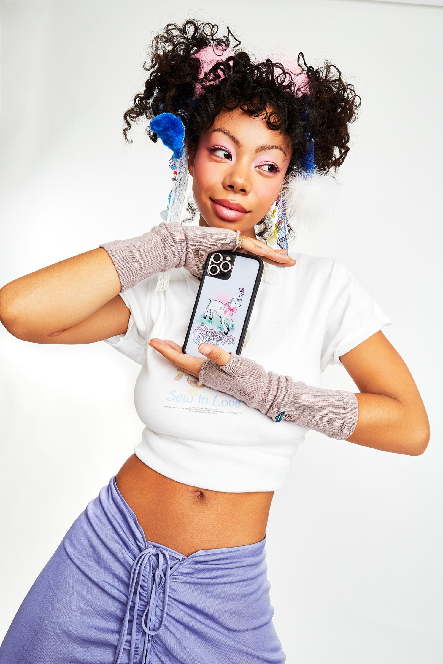a young woman holding up a phone and posing for a photo