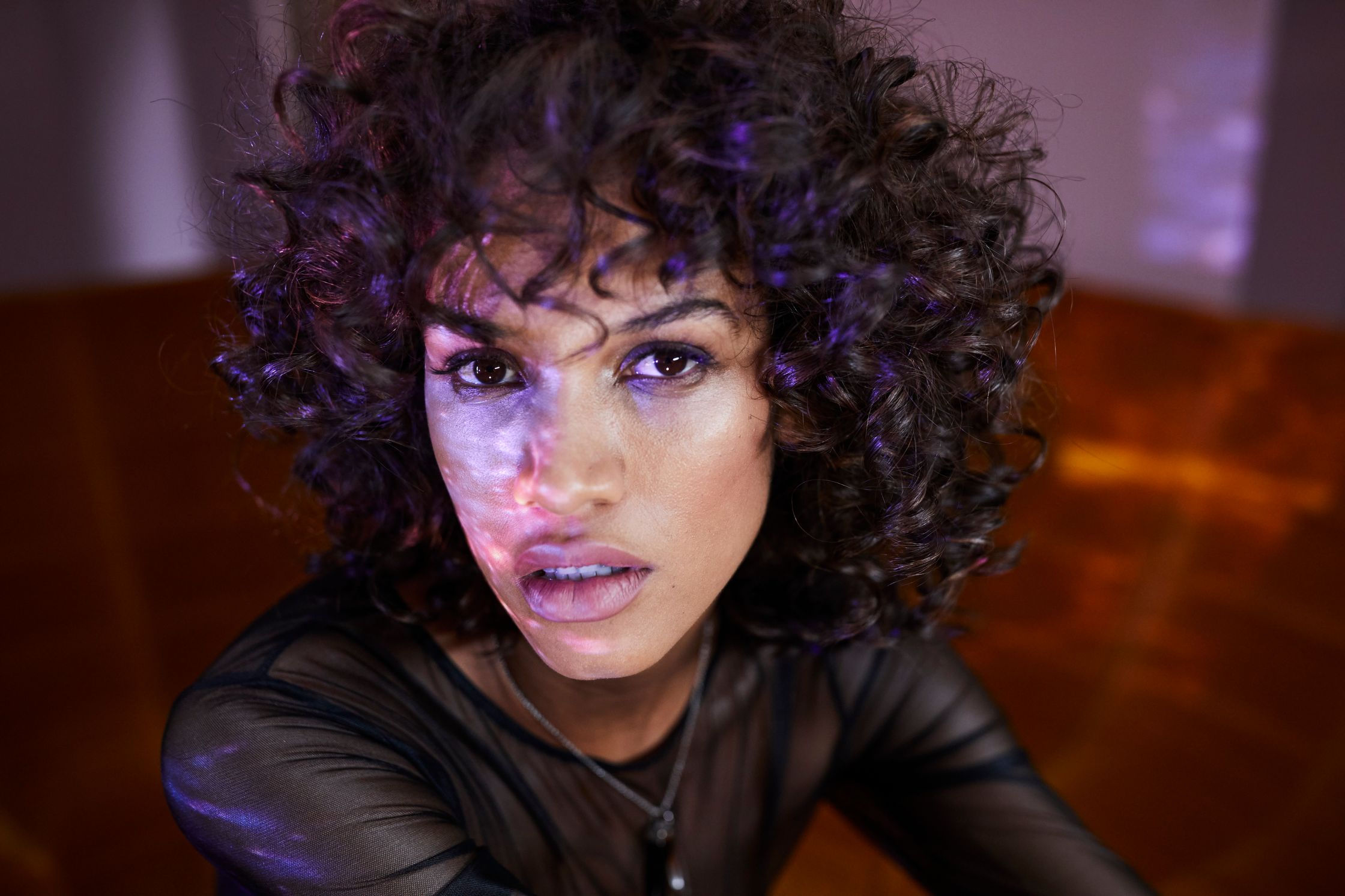 a woman with curly hair is posing for a photo