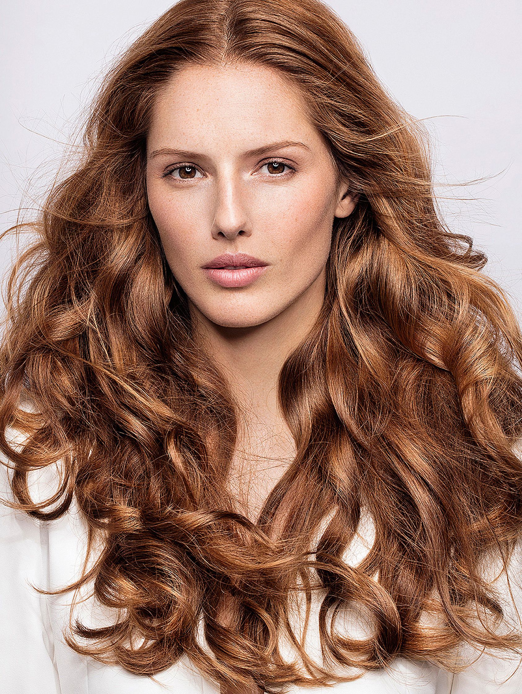 a woman with long curly hair is posing for a photo retouche hamburg