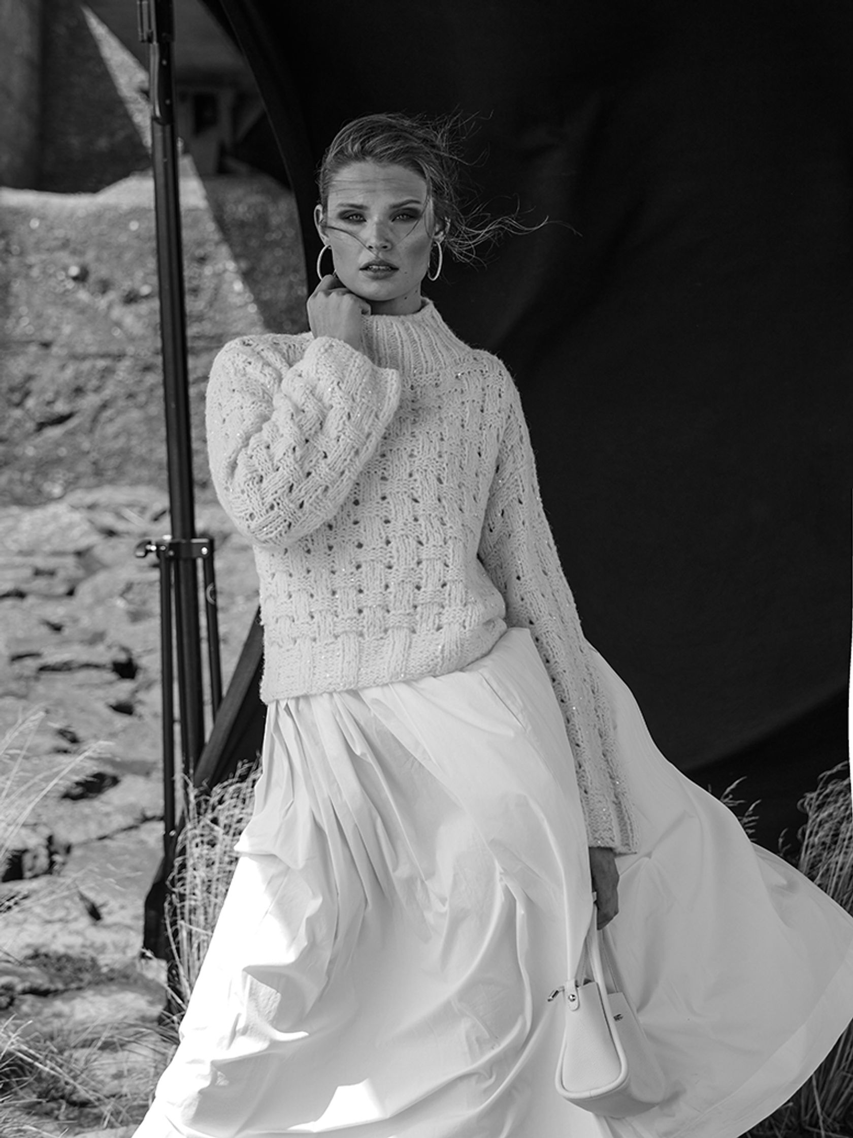 a woman in a white sweater and skirt