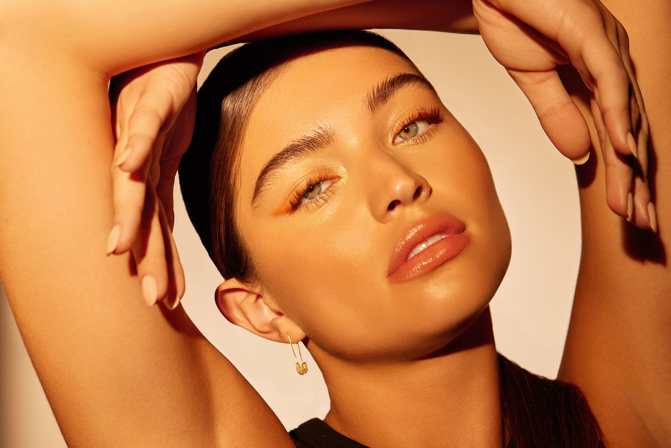 a woman is posing with her hands on her face