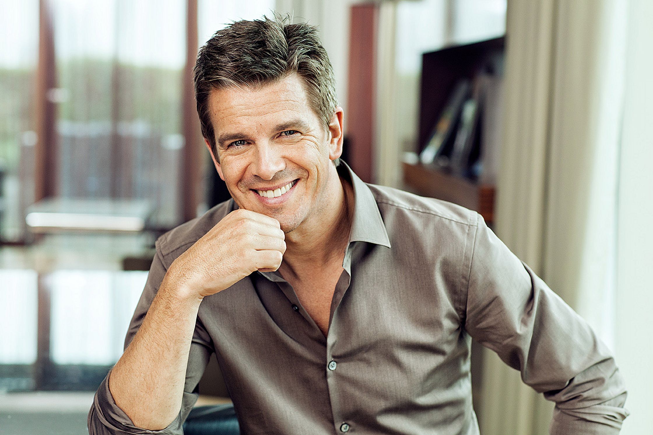 a smiling markus lanz in a brown shirt sitting at a table
post production by glamtouch