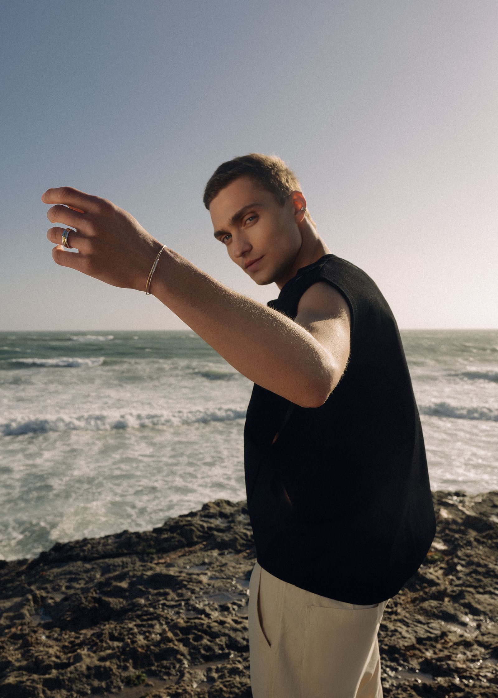 a man standing on a rock next to the ocean