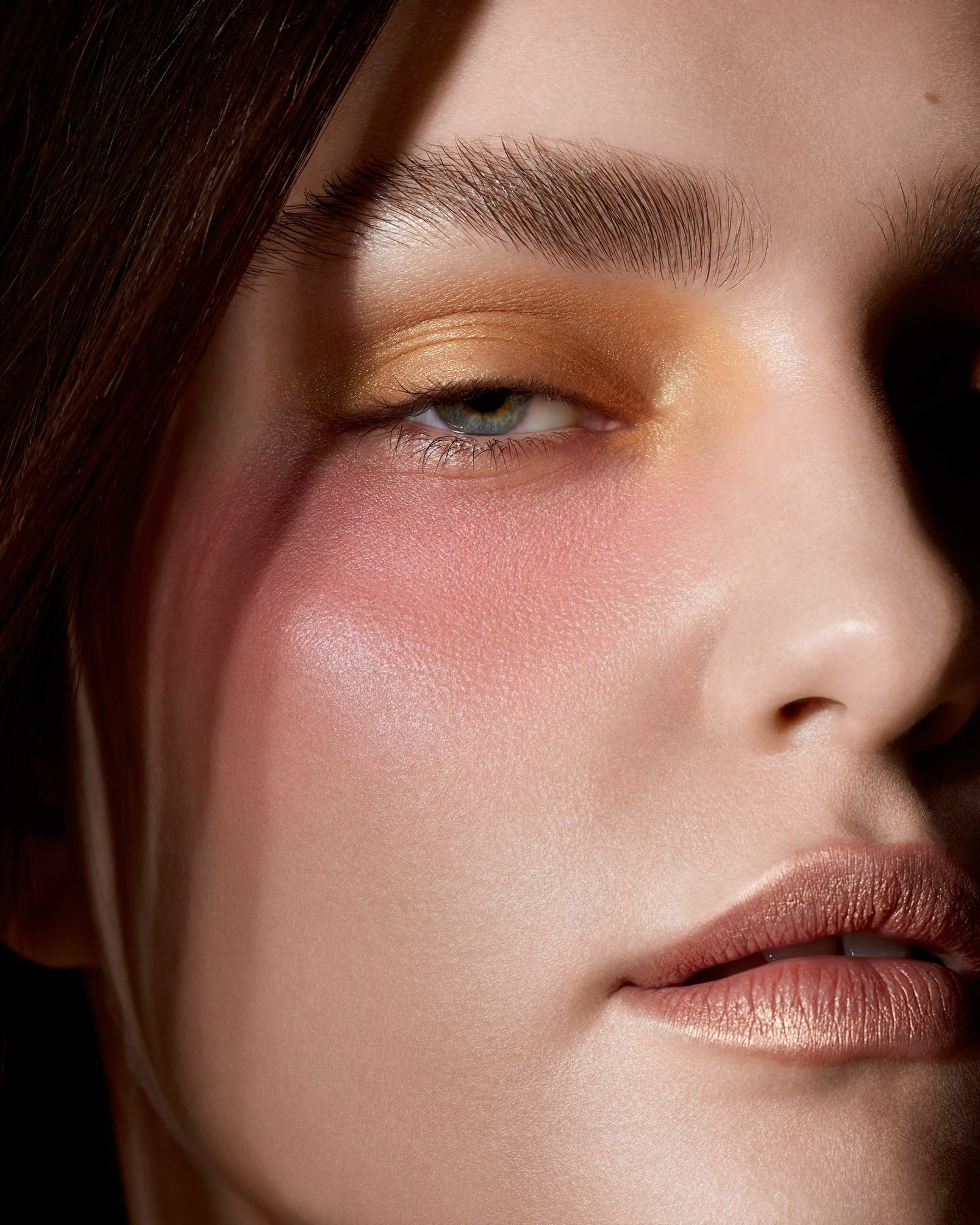 a close up of a woman's face with pink and yellow makeup