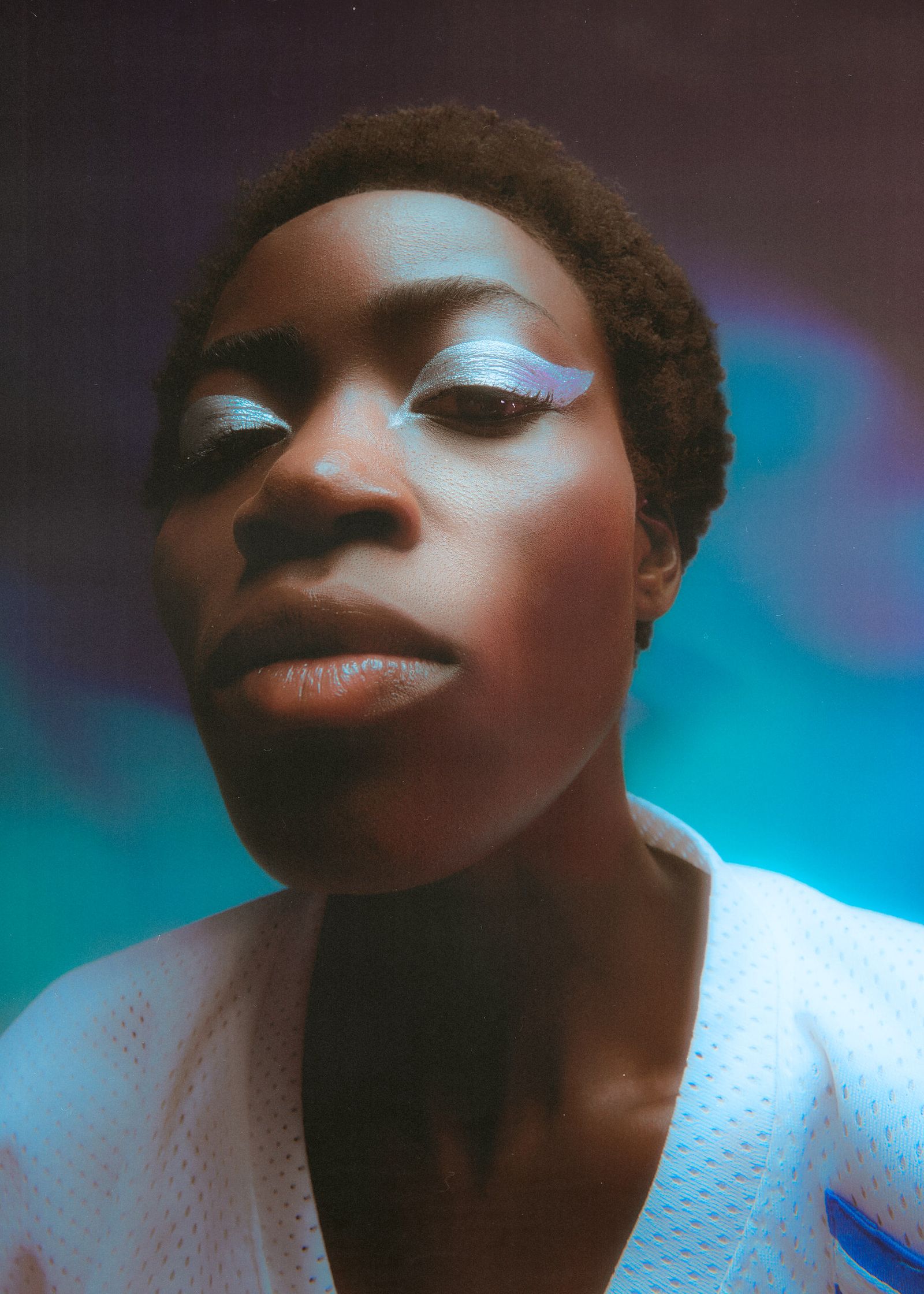 a portrait of a black woman with white eye makeup