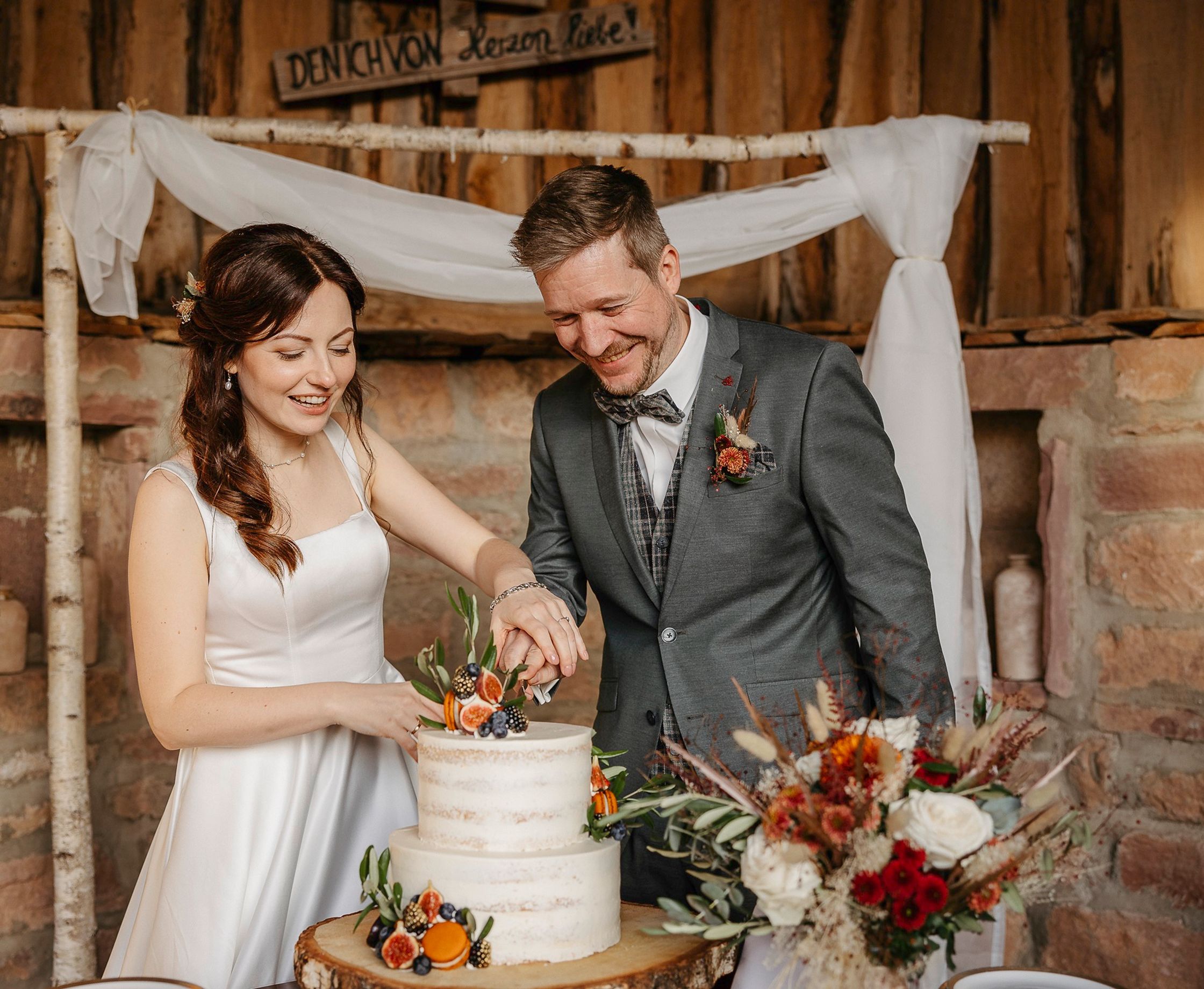 Eine Braut und ein Bräutigam schneiden ihre Hochzeitstorte an