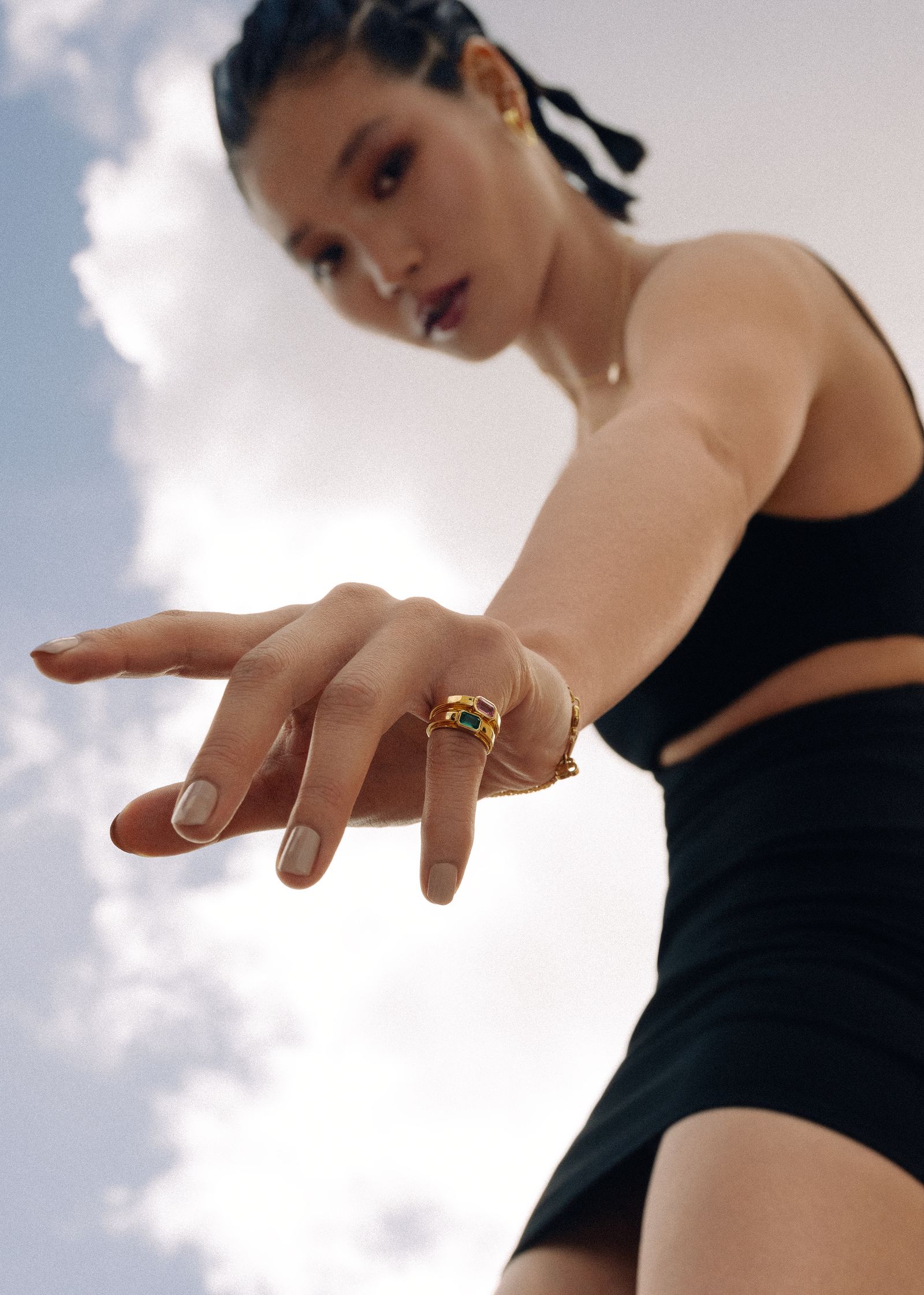 a woman wearing a black dress and a gold ring