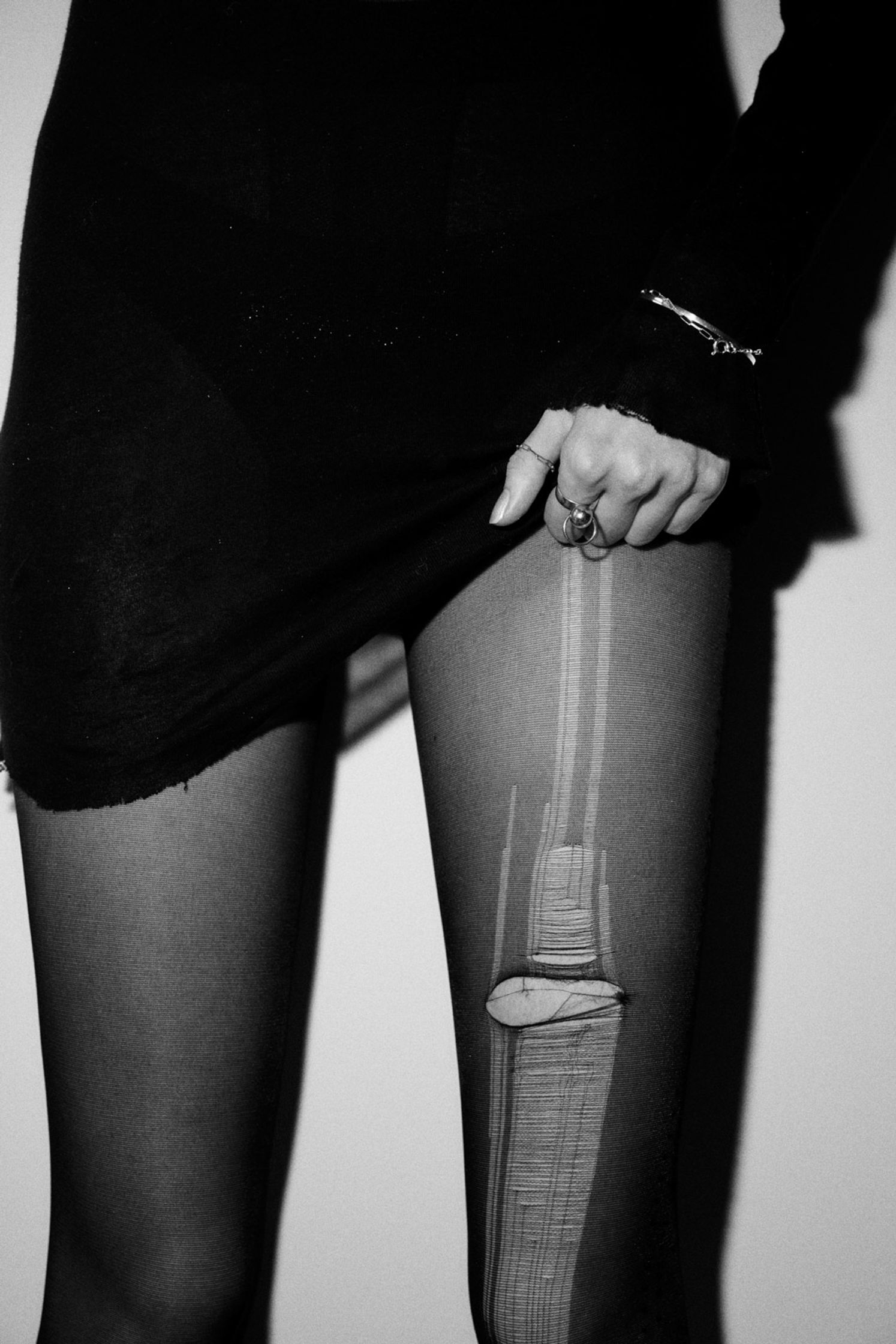 a black and white photo of a woman with a knife in her stockings