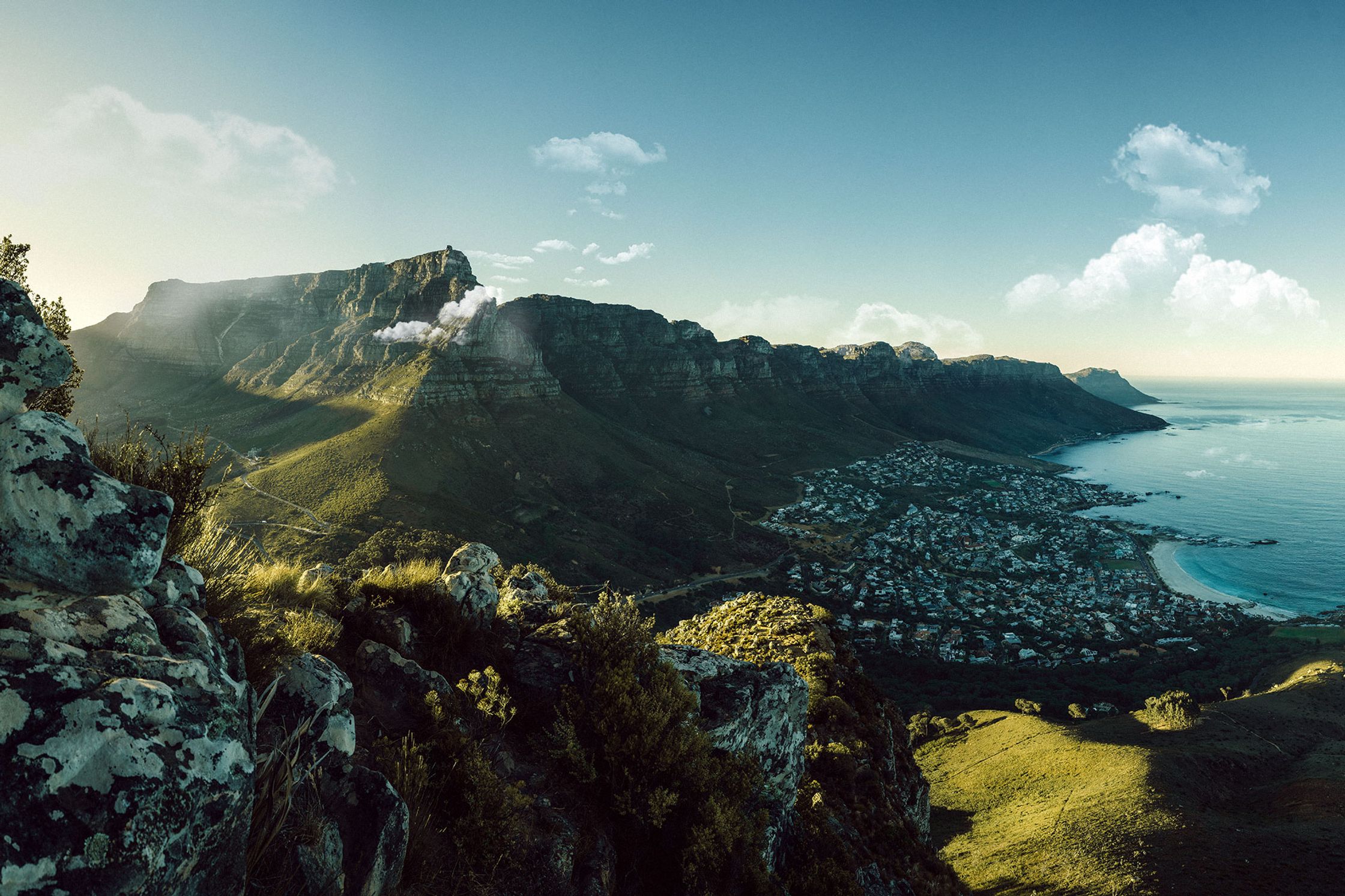 a view of cape town from the top of a mountain lion head. you can see the table mountain