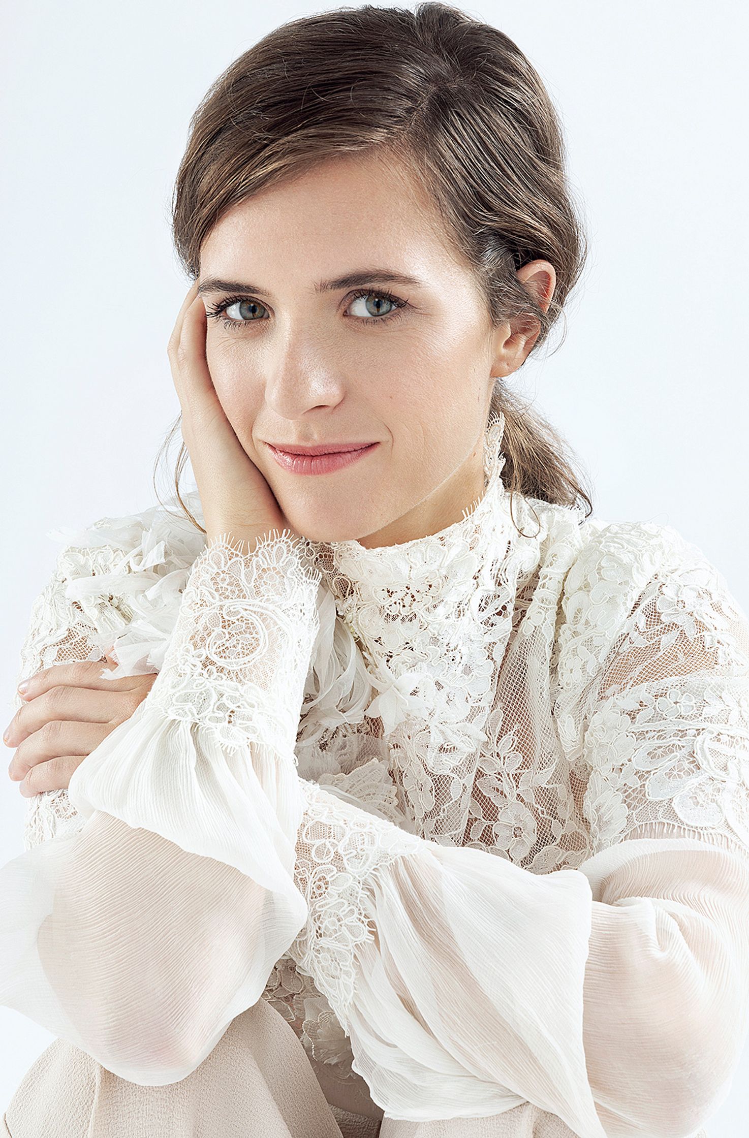 liv lisa fries in a white blouse posing with her hand on her chin