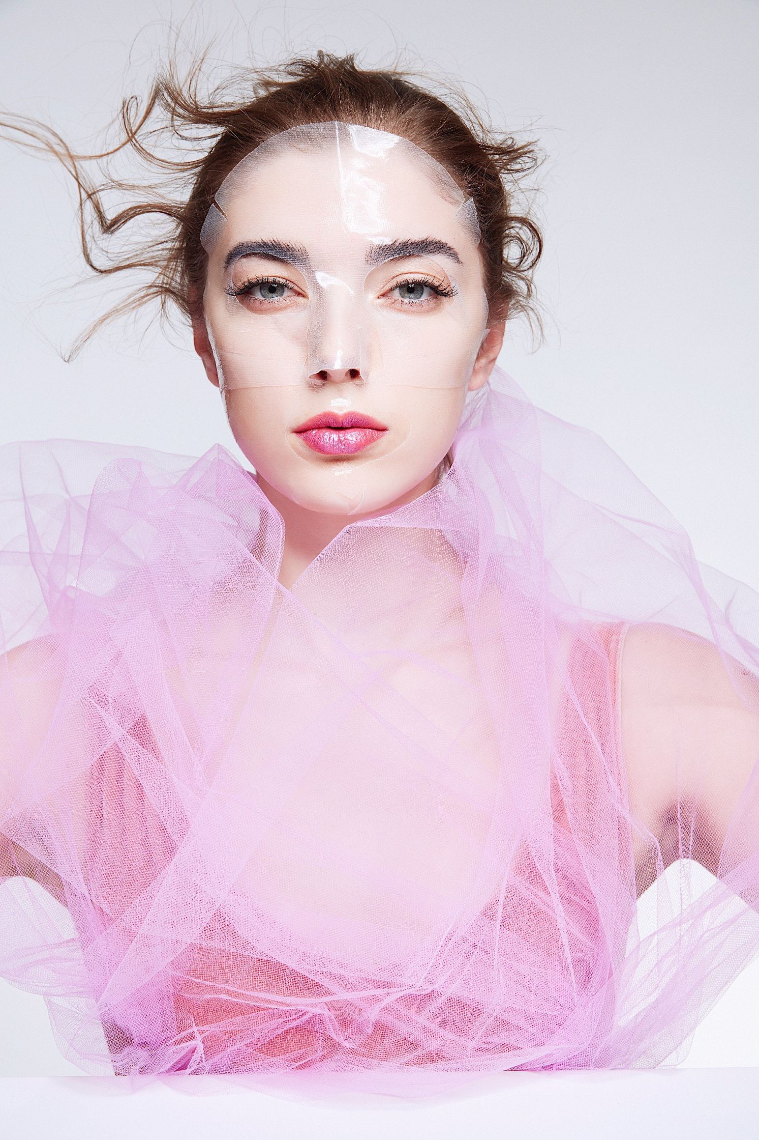 a woman wearing pink tulle posing on a white background