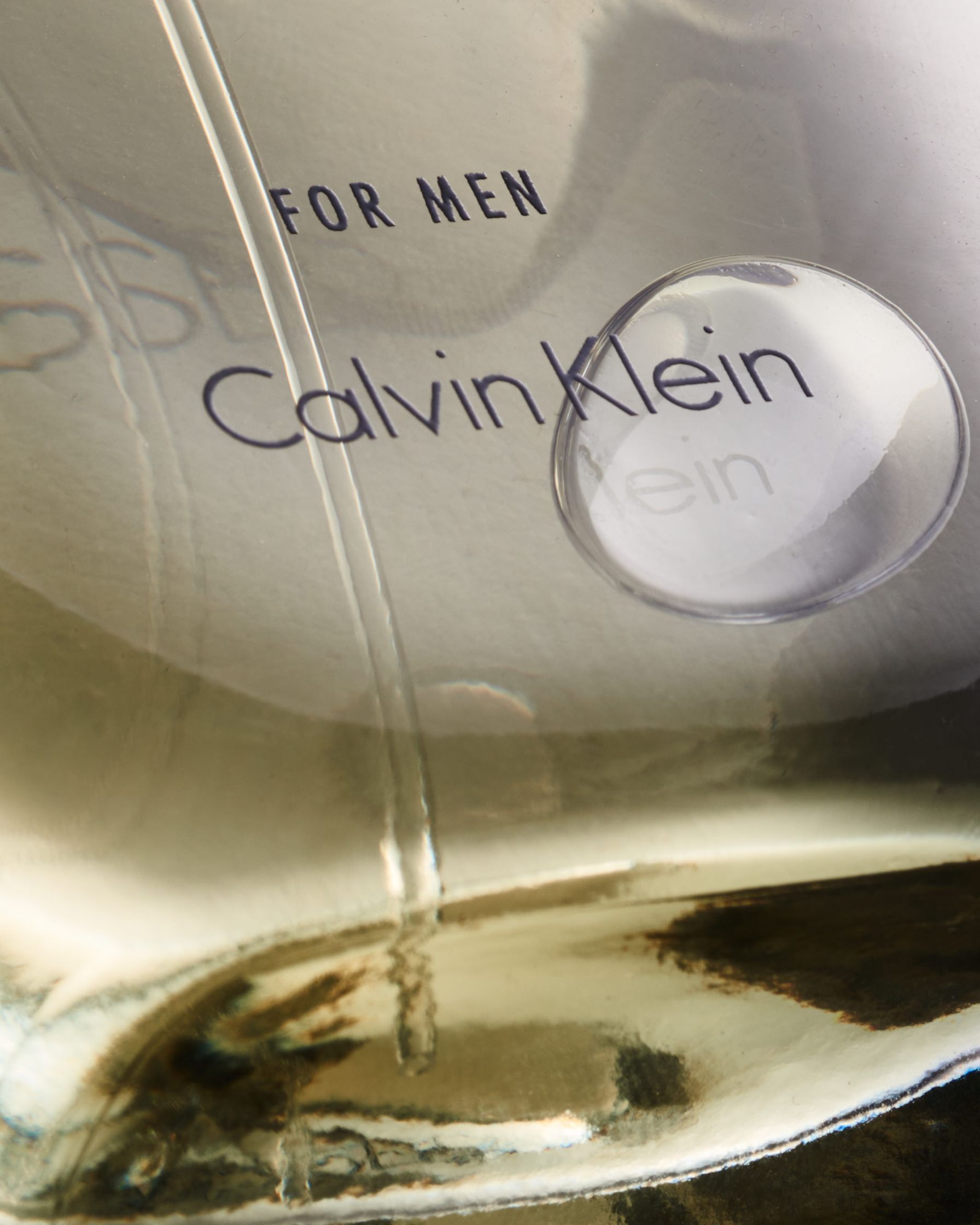 Artistic shot of Calvin Klein Obsessed perfume bottle with soft light reflection, emphasizing the clean and modern design.