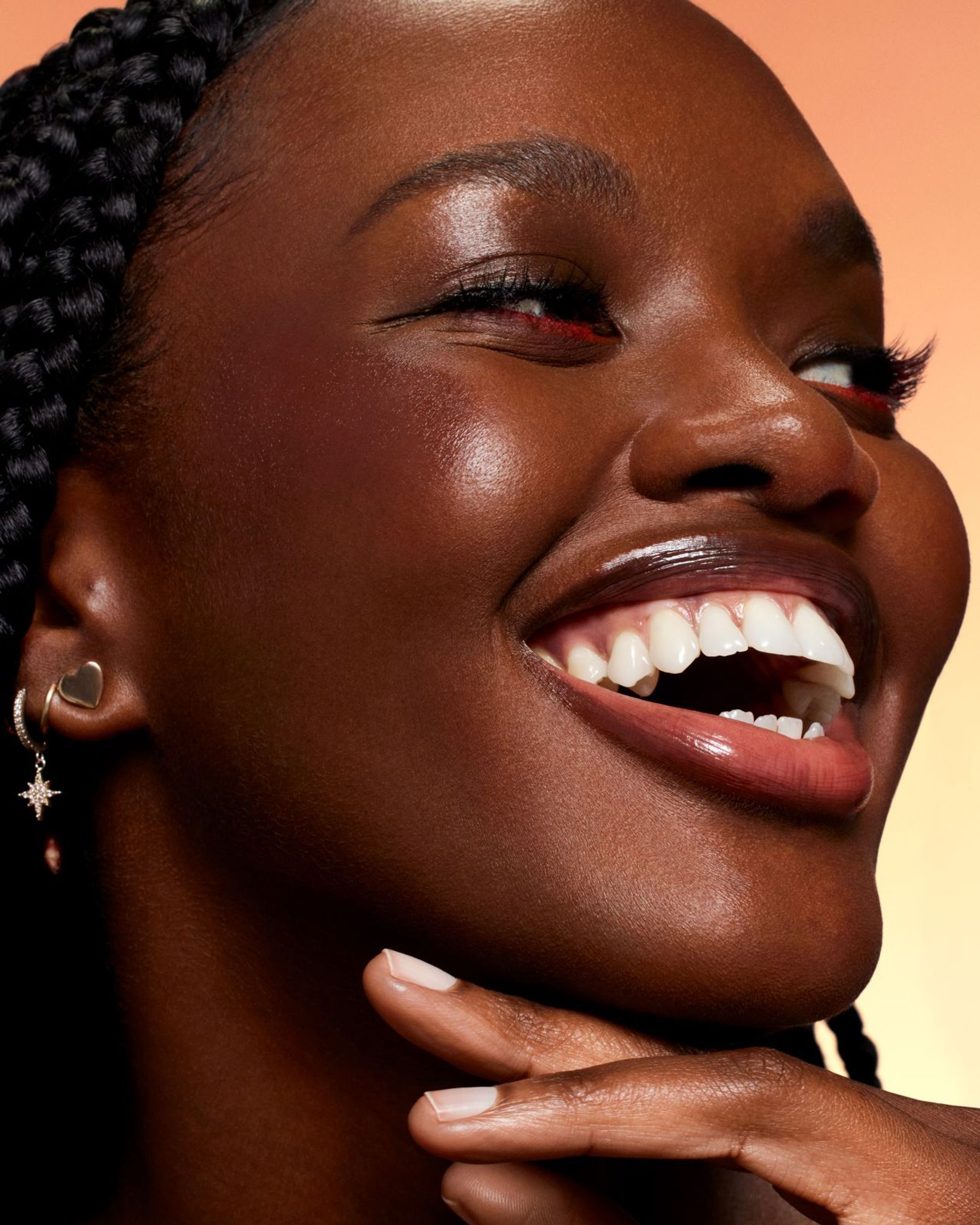 a black woman is smiling with her hands in her hair